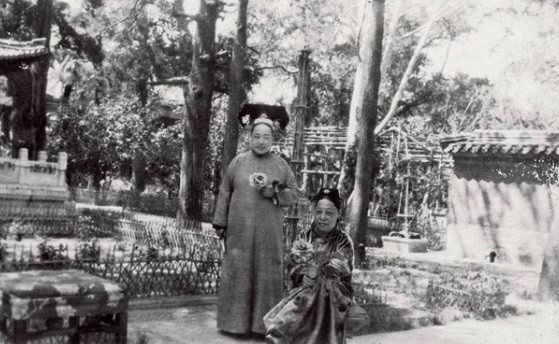 Đoan Khang quý phi hay còn gọi là Cẩn phi (bên phải ảnh) cùng một cung nữ hái hoa trong vườn thượng uyển.