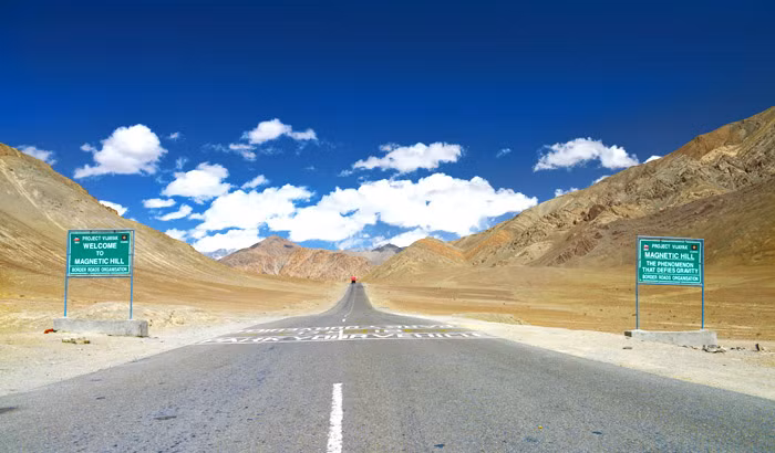 Theo đó, các biển báo hướng dẫn tài xế dừng ô tô trong ô kẻ trắng trên đường. Sau khi tắt máy và đỗ xe đúng điểm đánh dấu, họ sẽ chứng kiến hiện tượng lạ lùng là ô tô tự chạy lên dốc.