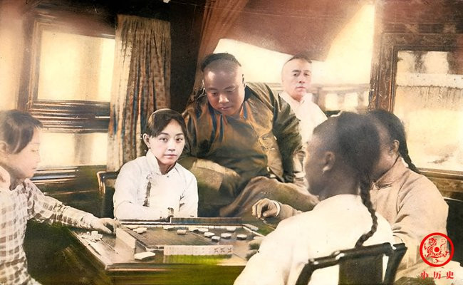 Một nhóm thanh niên chơi mạt chược, trong đám đông ấy nổi bật là người phụ nữ có vẻ đẹp sắc sảo.