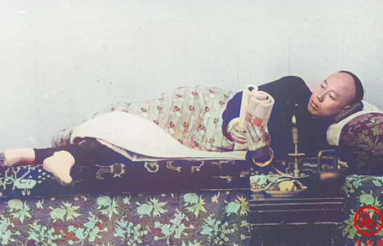 Người đàn ông nằm trên giường độc sách.