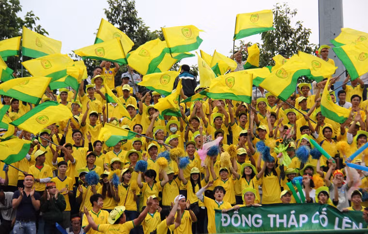 Trên SVĐ Gò Đậu (TP. Thủ Dầu Một, tỉnh Bình Dương) dù đến 17h giải đấu mới chính thức khai mạc và thiếu vắng ngôi sao tiền đạo Lê Công Vinh (Becmex Bình Dương) do mới cưới vợ nhưng từ hơn 3 giờ chiều, hàng nghìn người hâm mộ đã kéo đến sân. Trong số đó có rất đông CĐV của 2 đội Becamex Bình Dương và Đồng Tháp. Trong ảnh là một góc khán đài ngập sắc vàng của CĐV đội Đồng Tháp.