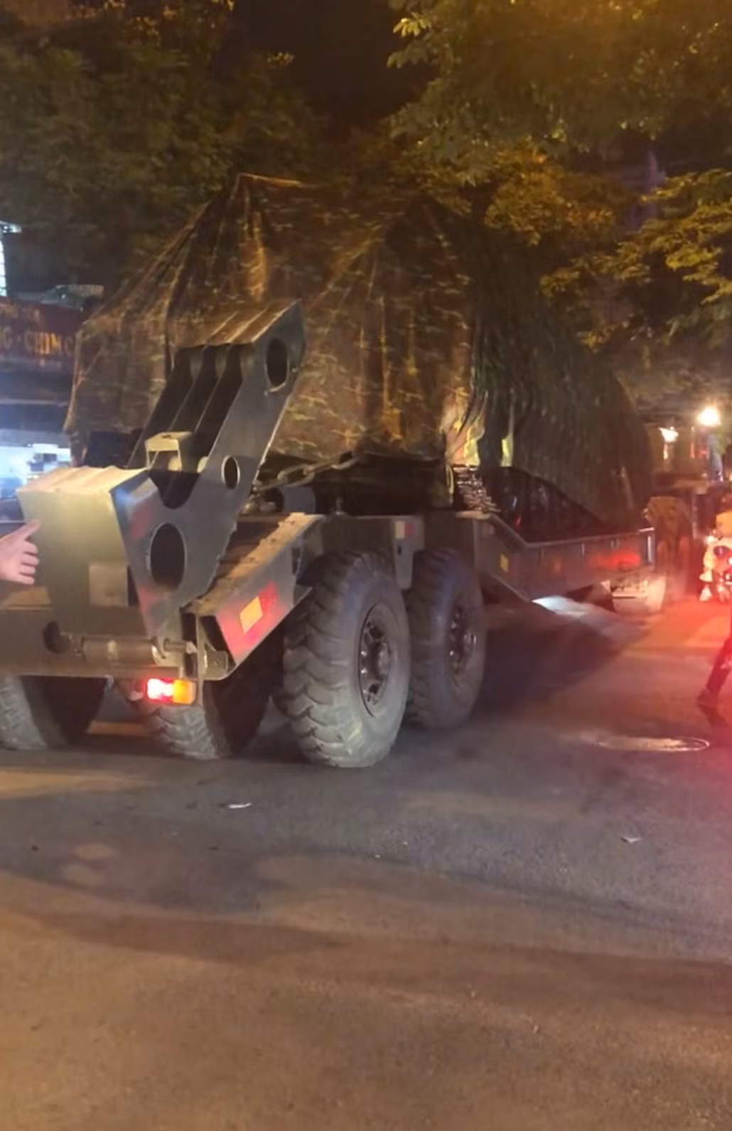 Ngoài tổ hợp tên lửa đạn đạo chiến thuật Scud-B, một loạt các khí tài hạng nặng khác cũng được lũ lượt di chuyển trong đêm, trong Đại hội vừa diễn ra, Quân đội ta đã cho trưng bày nhiều khí tài hạng nặng khác như xe tăng chiến đấu chủ lực T-90S/SK, xe tăng T-54B/M, xe tăng T-62, pháo phòng không tự hành Zsu-23-4, tổ hợp Strela-10, Ảnh: Phương tiện thiết giáp bánh xích được xe đầu kéo vận chuyển trên đường phố Hà Nội.