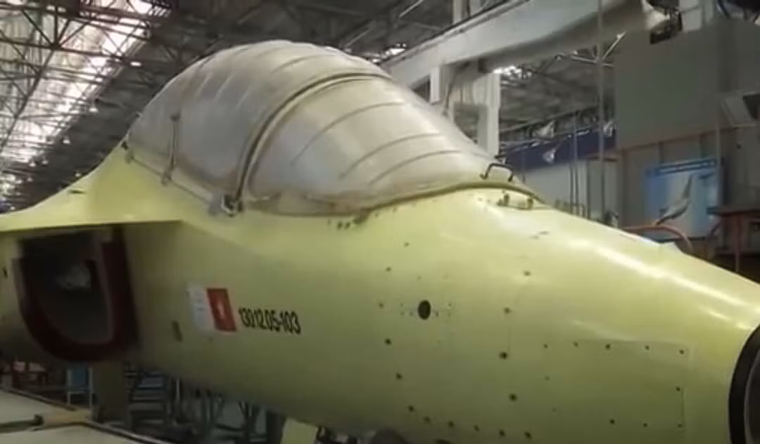 Mới đây, những hình ảnh đầu tiên về tiêm kích phản lực huấn luyện hiện đại hàng đầu thế giới này của Không quân ta đã chính thức lộ diện trên kênh truyền hình quốc gia Nga - Russian-1. Chiếc máy bay mang quốc kỳ Việt Nam trên khung thân chứng tỏ đây chính là chiếc Yak-130 thuộc lô 12 chiếc mà ta đặt mua từ nước bạn. Có thể thấy rằng tiêm kích này đã sản xuất gần như là hoàn tất chỉ thiếu radar ở mũi và sơn màu. Ảnh: Chiếc Yak-130 của Việt Nam tại nhà máy Nga. Ảnh: Chụp màn hình kênh Russia-1.