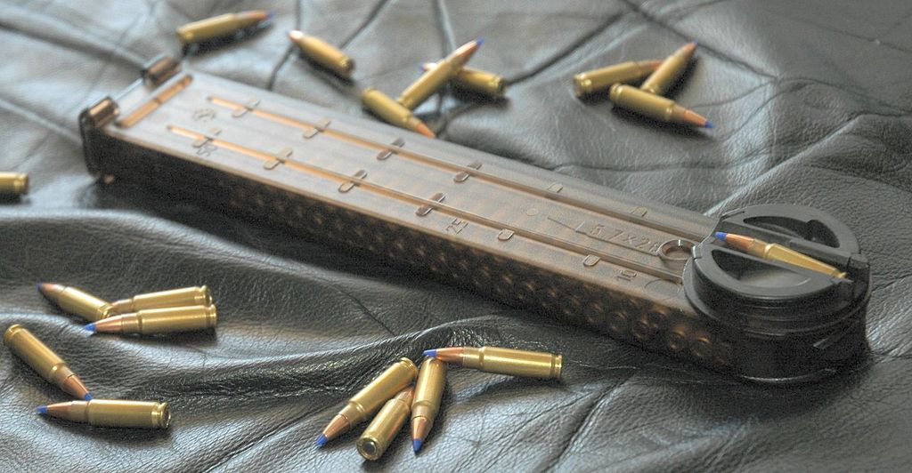 Ngoài ra P90 có một băng đạn khác thường, nằm phía trên nòng súng, cấu tạo này cho phép làm cho vũ khí nhỏ gọn nhất có thể. Hộp tiếp đạn được làm bằng polyme, nên nhìn rõ được đạn bên trong, sức chứa được 50 viên; đây là sức chứa ấn tượng đối với một khẩu súng tiểu liên. Hiện P90 phục vụ trong quân đội của 50 quốc gia. Ảnh: Hộp tiếp đạn và đạn của P90 - Nguồn: Wikipedia.