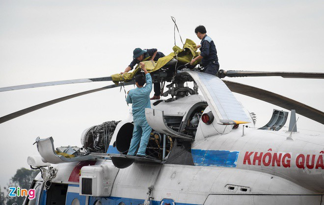 Ngay từ rất sớm, tổ thợ máy đã bắt đầu công việc chuẩn bị sẵn sàng cho trực thăng làm nhiệm vụ như lắp dây tời để thả hàng hóa cũng như đổ bộ người cứu hộ, vận chuyển hàng tiếp tế cho những người mắc kẹt. Hiện nay đang có 17 công nhân đang mất liên lạc trong khu vực nhà máy thủy điện Rào Trăng 3 cùng 13 người trong đoàn tìm kiếm đã bị lũ cuốn trôi. Ảnh: Tổ máy chuẩn bị sẵn sàng cho trực thăng cất cánh - Nguồn: Zing.