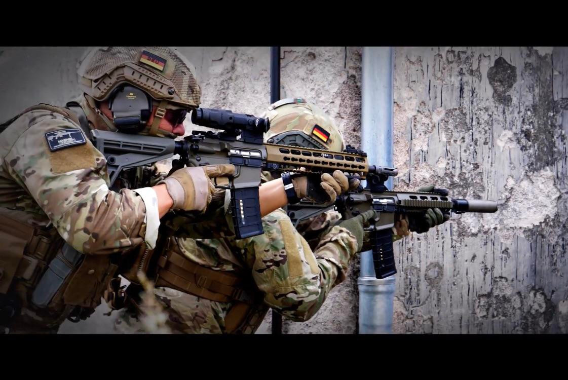 Trên thực tế, dù cho CG Haenel chỉ có giá trị doanh thu bằng 1/30 của công ty Heckler &amp; Kock tuy nhiên Haenel lại có một bề dày lịch sử vô cùng đáng ngưỡng mộ. Heckler chỉ mới được thành lập từ những năm đầu sau Chiến tranh Thế giới lần thứ 2 thì Haenel đã ghi dấu sự thành lập lịch sử của mình từ giữa thế kỷ XIX. Tại thời điểm đó, bên cạnh sản xuất các loại vũ khí cỡ nhỏ, công ty cũng kinh doanh và sản xuất thêm cả mặt hàng xe đạp - một món đồ vô cùng đại trà ở thời điểm đó. Ảnh: Lính Đức với MK-556.