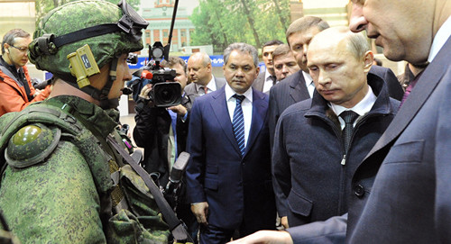 Việc trang bị AK-12 nhằm đồng bộ hóa với hệ thống chiến đấu tương lai Ratnik, gồm áo giáp, thiết bị liên lạc cá nhân, máy tính, thiết bị quan sát ban đêm và bộ y tế cá nhân. Tuy nhiên việc trang bị hệ thống chiến đấu tương lai của Nga đã phải trì hoãn vì thiếu kinh phí. Ảnh: Tổng thống Nga Vladimir Putin và Bộ trưởng Sergei Shoigu (giữa) quan sát mẫu Ratnik trong một chuyến thăm thành phố Izhevsk - Nguồn: Sputnik