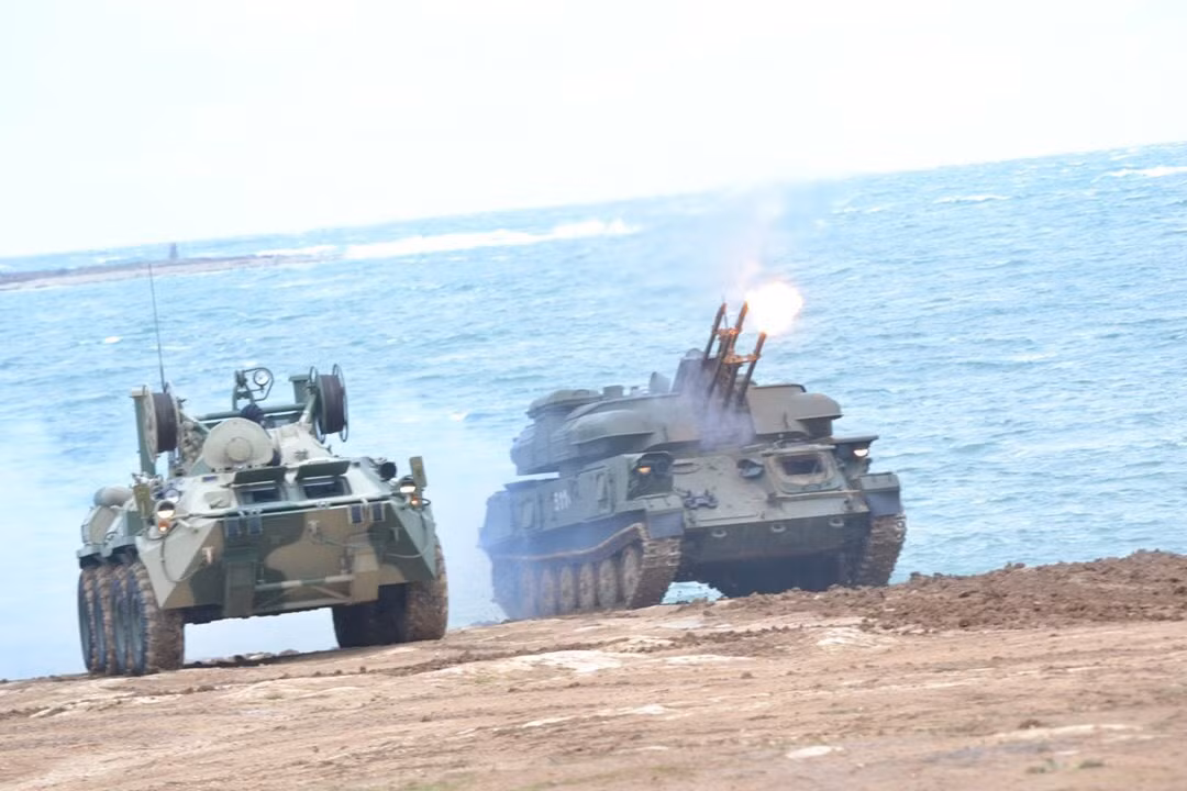 Hệ thống pháo phòng không tự hành cao tốc đa nòng nổi tiếng không kém do Liên Xô phát triển từ trong chiến tranh Lạnh là Zsu-23-4 Shilka, được trang bị và viện trợ cho nhiều quốc gia trên thế giới. Pháo sử dụng 4 nòng pháo 2A7 cỡ 23mm, mỗi khẩu có tốc độ bắn khoảng 850 - 1.000 phát/phút và tốc độ bắn tổng hợp là khoảng 4.000 phát/phút, tạo ra một màn đạn vô cùng dày đặc. Hệ thống được bổ sung radar tìm kiếm mục tiêu RPK-2 có tầm phát hiện tối đa tới 20km. Ảnh: Pháo Zsu-23-4 khai hỏa chế áp mục tiêu bay cho phương tiện bọc thép đổ bộ.