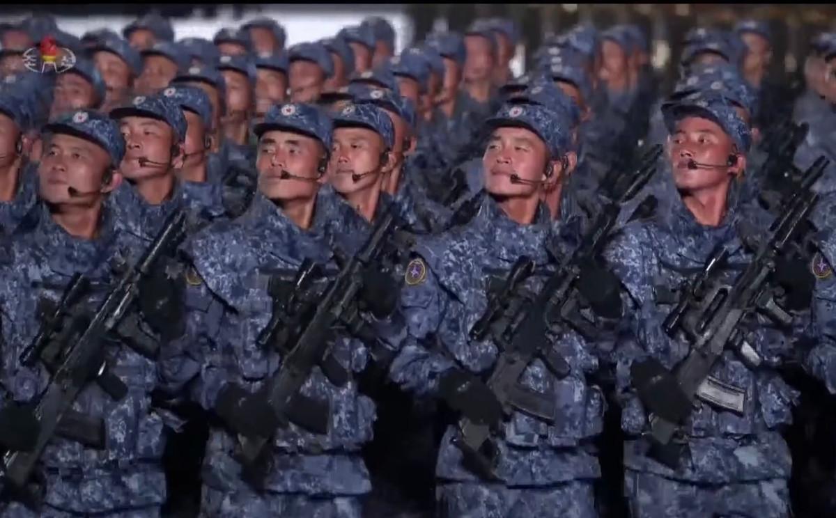 Đây cũng là lần đầu tiên triều Tiên cho ra mắt mẫu súng trường tấn công kiểu mới, có hình dạng bên ngoài khá giống với mẫu QBZ-95 của Trung Quốc nhưng thực tế lại là phiên bản Bullup của súng trường Type-88. Ngoài ra mẫu nòng giảm thanh mới cũng được giới thiệu với một thiết kế cực kỳ lạ mắt, chưa rõ tính năng thực tế nhưng khả năng là có thể triệt âm và triệt tiêu luôn tia lửa đầu nòng khi bắn. Ảnh: Khối chiến sĩ Triều Tiên với súng trường mới.