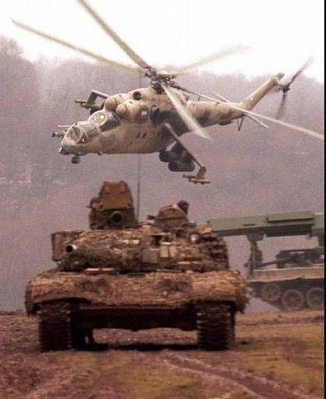 Mil Mi-24 là trực thăng vũ trang vô cùng nổi tiếng được thiết kế chế tạo từ những năm 1970 dưới thời Liên Xô, cho đến nay sau nhiều phiên bản cải tiến nâng cấp, nó vẫn xứng danh là một trong những trực thăng tấn công có sức mạnh hàng đầu trên thế giới, nỗi khiếp sợ của bộ binh đối phương. Đặc điểm nhận dạng của Mi-24 hiện nay là buồng lái đặc trưng, kíp lái 2 người ngồi trên - dưới thay vì ngồi song song, được bọc bởi một khoang hình giọt nước có thể chống lại các loại đạn bộ binh. Ảnh: Mi-24 phối hợp tác chiến cùng xe tăng T-72 của Liên Xô.