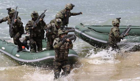 Quan sát kỹ không khó để nhận thấy, lòng bàn tay của binh lính về cơ bản chỉ có thể cầm được nửa vòng của hộp tiếp đạn; như vậy, liệu sức nặng của hộp tiếp đạn có giữ được chắc súng khi bắn? Ảnh: Ngay cả trong cuộc tập trận, các lực lượng đặc biệt của Triều Tiên chỉ mang theo một hộp tiếp đạn vì quá nặng - Nguồn: Sina