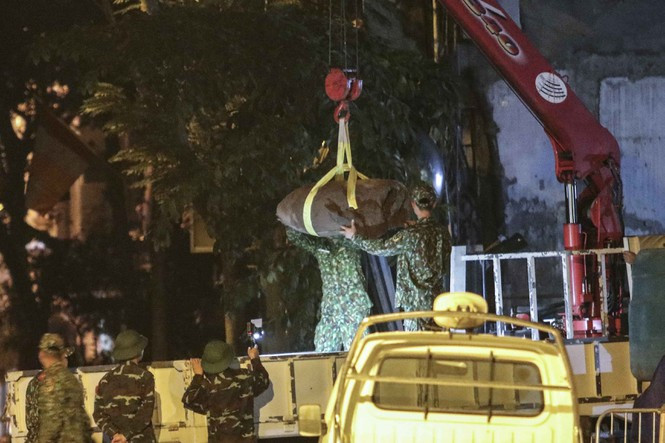 Đến 23h45 29/11, quả bom đã hoàn toàn được đưa lên xe, rời khỏi phố Cửa Bắc. Quả bom được tìm thấy có trọng lượng 340kg, đường kính 400mm và dài 125cm. Ảnh: Quả bom được đưa lên xe vận tải an toàn - Nguồn: Tiền Phong.