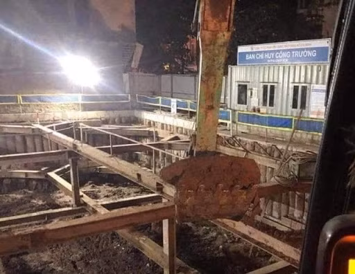 Đến 23h30 đêm 29/11, các đơn vị đã xử lý thành công quả bom ở phố Cửa Bắc và nhanh chóng đưa nó ra khỏi hiện trường. Chiếc máy xúc đã đưa quả bom lên khỏi nơi nó được phát hiện sâu 6m so với vỉa hè, sau đó được máy cẩu đưa lên xe an toàn. Ảnh: Máy xúc trục kéo quả bom lên khỏi mặt đất - Nguồn: Vietnamnet.