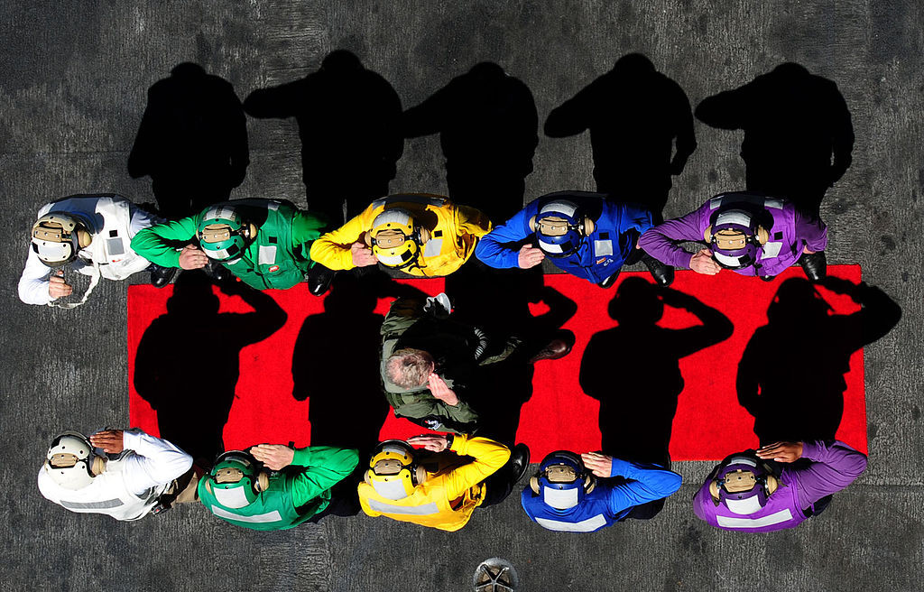 Để đảm bảo hoạt động thông suốt và chỉnh chu, mỗi bộ phận đảm nhận một nhiệm vụ trên boong tàu sân bay sẽ được trang bị một màu áo khác nhau, rất sặc sỡ và dễ nhận biết kể cả trong trường hợp tầm nhìn kém, thời tiết xấu. Nguồn ảnh: Pinterest.