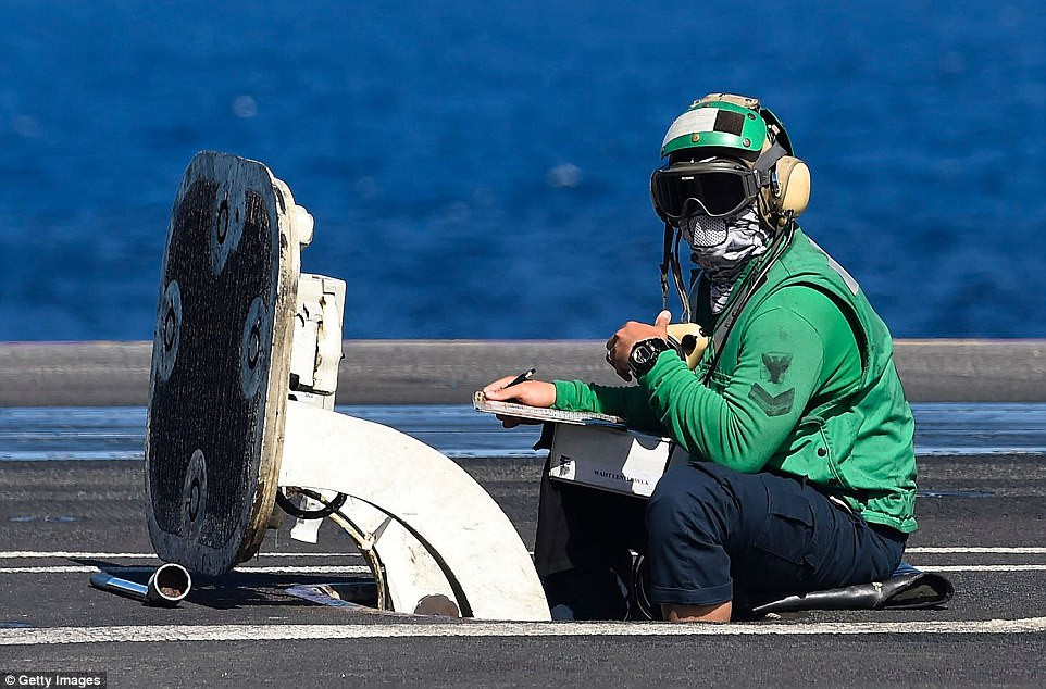 Tiếp đến là màu xanh lá cây - những nhân viên thực hiện nhiệm vụ nguy hiểm nhất trên hàng không mẫu hạm - đó là kiểm tra và bảo dưỡng dây cáp hãm cho máy bay hạ cánh. Nguồn ảnh: Pinterest.