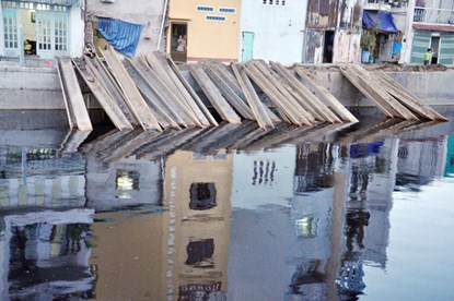 Những miếng ván dày đặc hai bên bờ kênh.