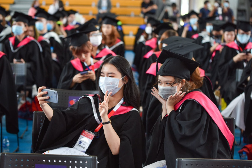 Hai nữ sinh lưu lại kỷ niệm đáng nhớ bên nhau và không quên đeo khẩu trang để đảm bảo an toàn. Lễ tốt nghiệp của Đại học RMIT được lên kế hoạch tổ chức sớm hơn, nhưng trường quyết định lùi lại vì lo ngại tình hình dịch Covid-19.