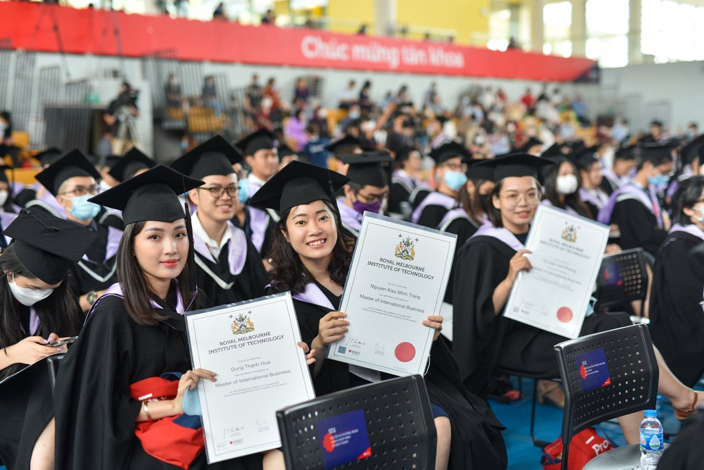 Các tân cử nhân Đại học RMIT giơ cao tấm bằng cử nhân - thành quả cho những năm tháng học tập, phấn đấu.