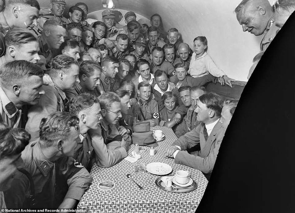 Hitler trò chuyện với những thanh niên hâm mộ, sùng bái y tại một quán cafe năm 1923.