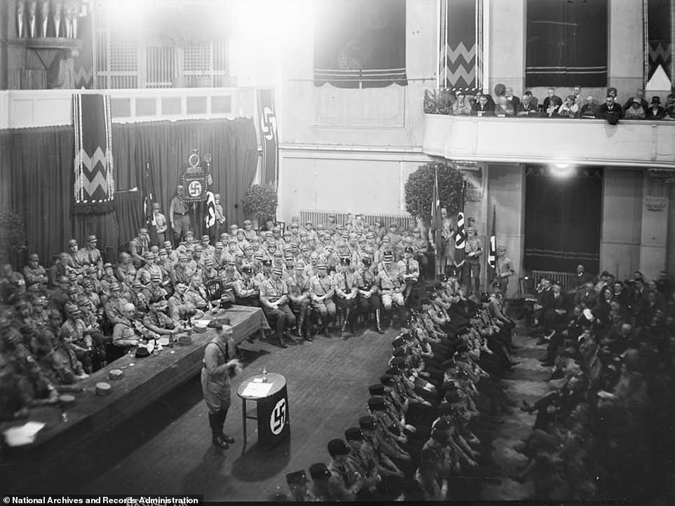 Hitler có bài phát biểu quan trọng. Mọi người trong khán phòng chăm chú lắng nghe những lời phát biểu của nhà độc tài phát xít Đức.