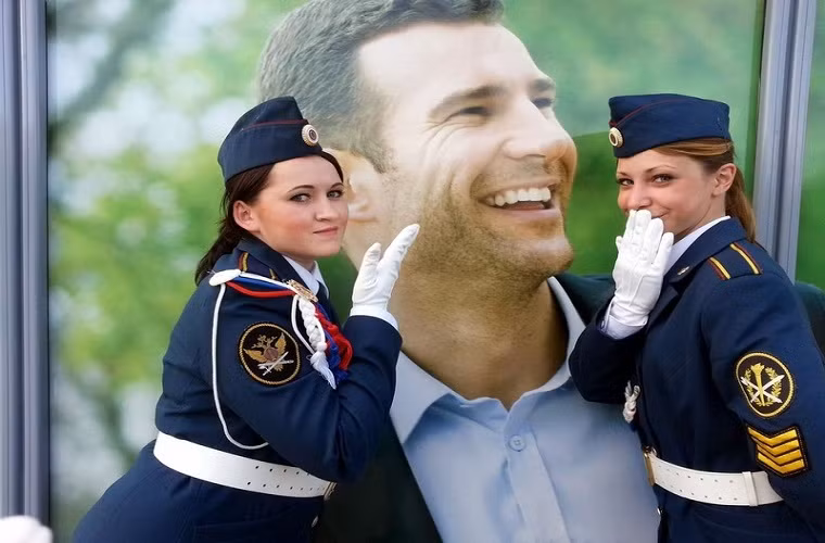 Hồn nhiên tạo dáng với một áp phích quảng cáo bên đường.