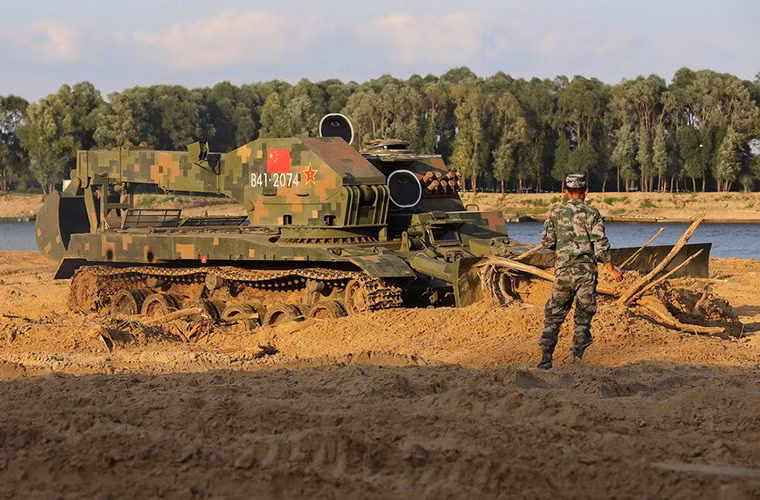 Một binh sĩ Trung Quốc đứng ở ngoài hướng dẫn cho đồng đội ngồi bên trong GCZ-112 thực hiệu phần thi loại bỏ chướng ngại vật của mình.