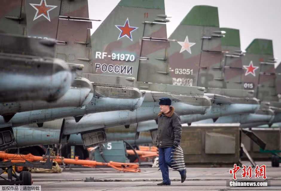 Cán bộ kĩ thuật đang đưa dây đạn pháo tới lắp cho các máy bay cường kích Su-25SM.