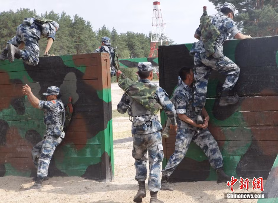 Bắc thang tay đẩy đồng đội vượt tường cao.