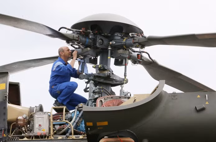 Thợ kỹ thuật đang xem xét kỹ trước khi cho chiếc trực thăng Super Puma SA-332 của Thụy Sĩ cất cánh tại triển lãm.