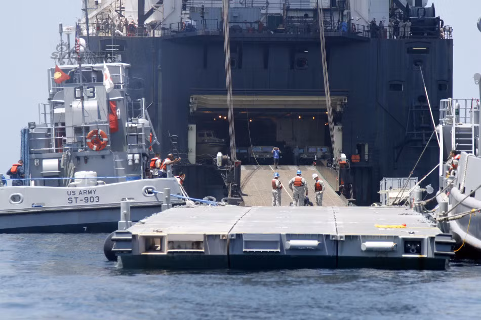 Cầu phao được kết nối với tàu đổ bộ Perryville (LCU 2034) của Quân đội Mỹ để chuẩn bị đón các phương tiện, vũ khí.