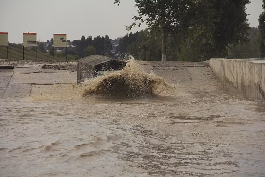 Chiếc xe chạy mạnh làm tung nước dữ dội.
