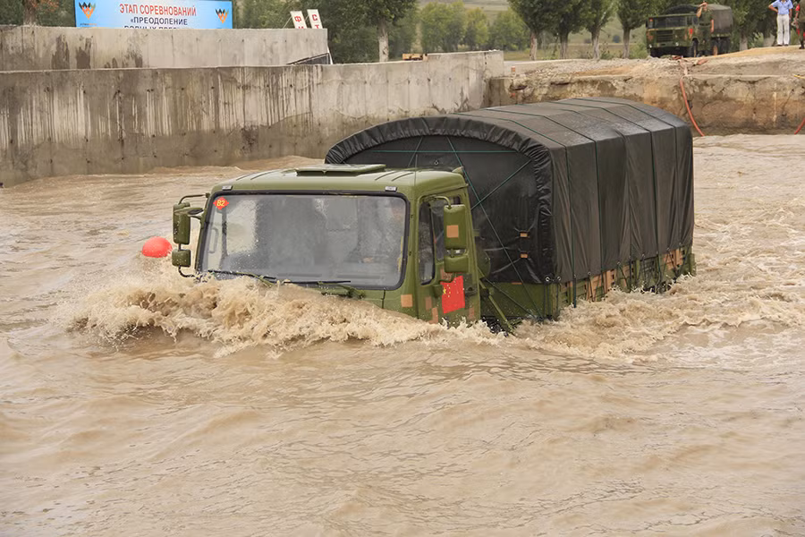 Trong khi đó một chiếc xe tải quân sự hạng nặng loại bánh lốp 6x6 SX2510 đang lội nước gập nửa cabin ở bên tuyến đường kế bên.