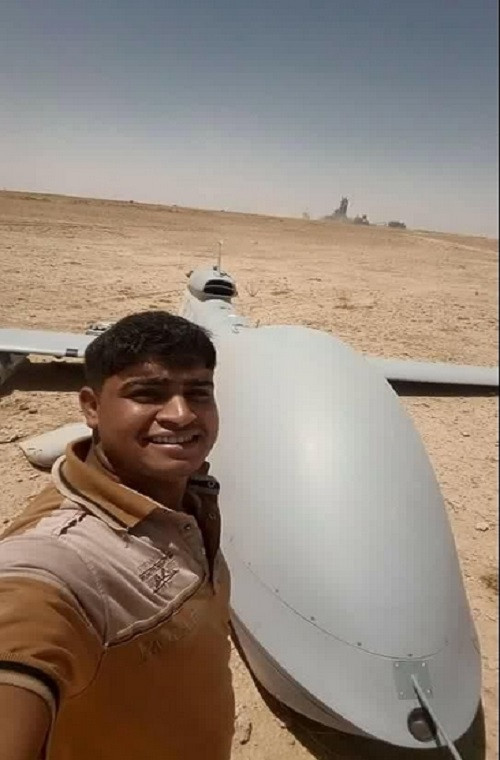 Một người dân Iraq chụp ảnh bên cạnh xác chiếc UAV MQ-1 của Quân đội Mỹ.