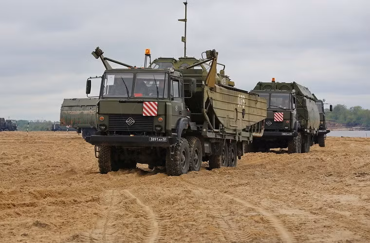 Trong ảnh là xe chở ca-nô công binh BMK-225 và các mảng cầu phao PMP di chuyển đến địa điểm huấn luyện nằm dọc ven sông.