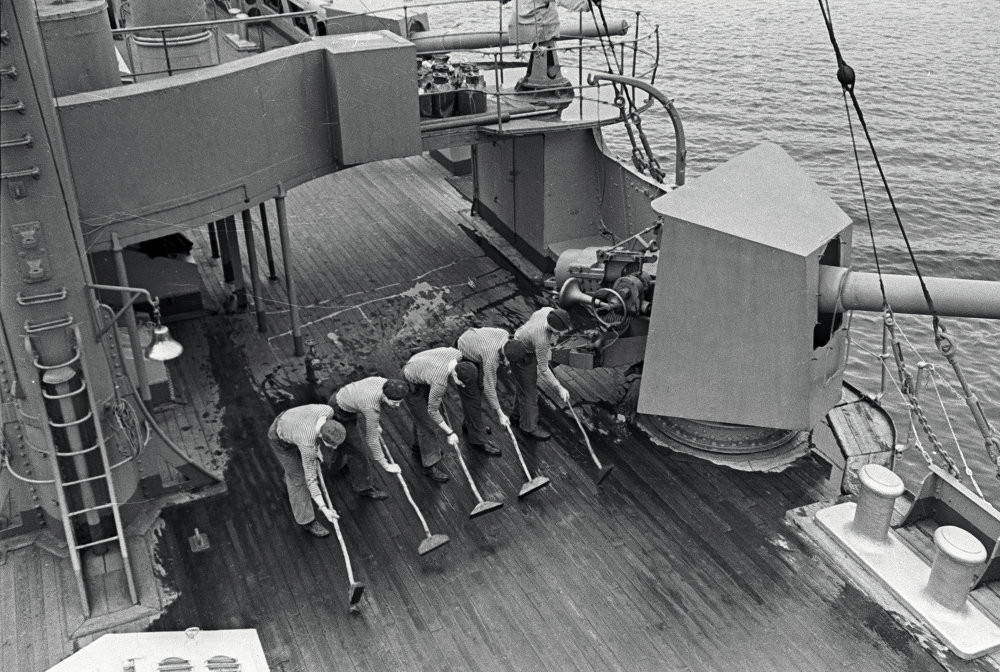 Tuần dương hạm Rạng Đông dài 126,8 mét, trọng tải dãn nước 6.731 tấn. Vũ khí ban đầu của con tàu gồm pháo và ngư lôi. Ảnh: các thủy thủ đang lau dọn sàn tàu. Nguồn: English Russia