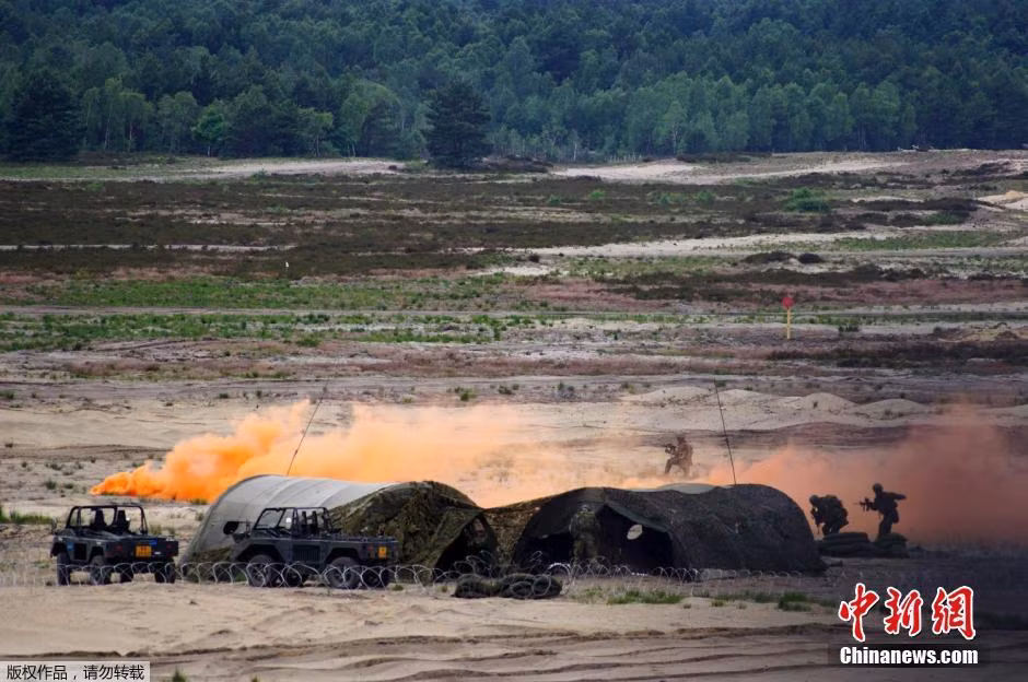 Các binh sĩ khối NATO đang thực hiện tấn công mục tiêu với sự yểm trợ bởi bom khói.
