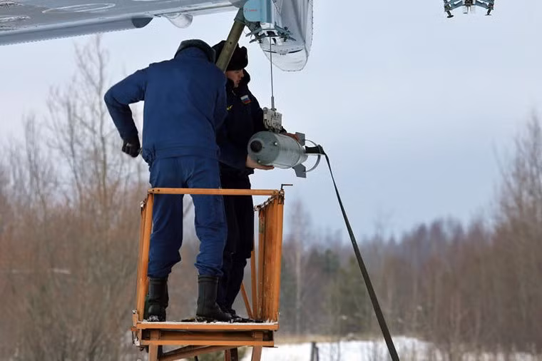 Kéo từng quả bom lên giá treo.