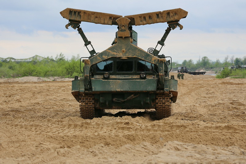 Khi di chuyển, hệ thống lưỡi ủi này có thể được kéo gấp ở phía trên. Xe có kíp lái 2 người và mang theo được 8 lính công binh khác.