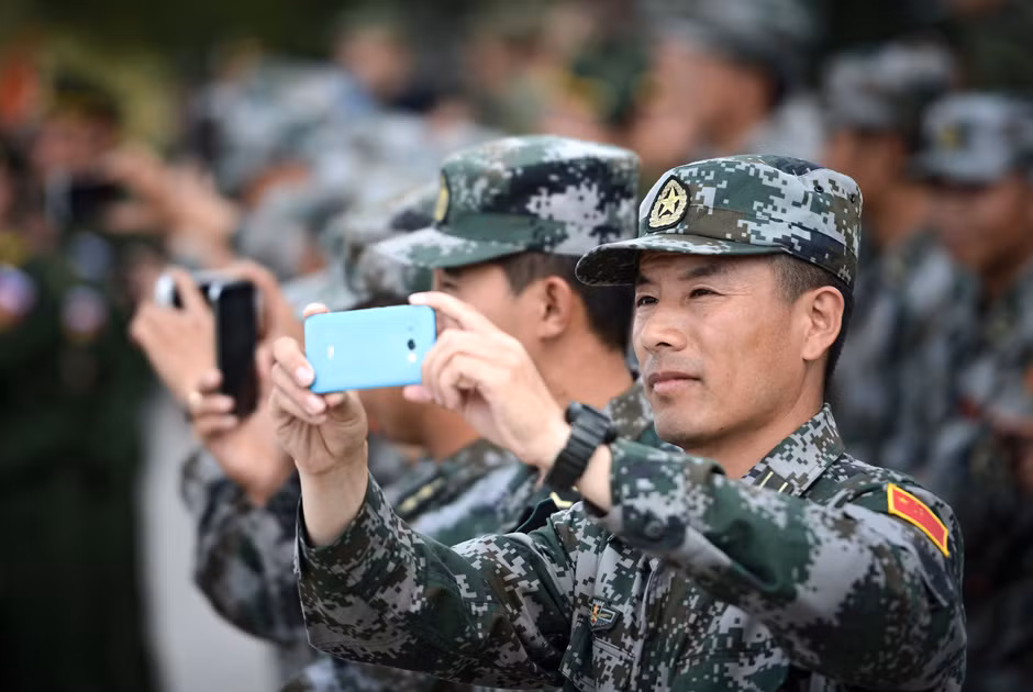Lính Trung Quốc tham gia cuộc thi đua nhau lấy smartphone quay lại các pha biểu diễn của lính Nga.