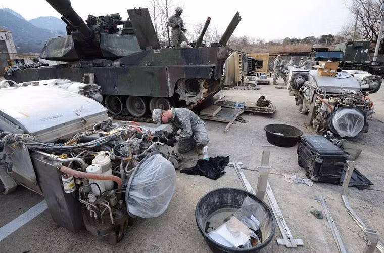 Trong ảnh, động cơ tuabin khí của xe tăng M1A2 Abrams được tháo hoàn toàn khỏi xe tăng đang được các binh sĩ bào trì.