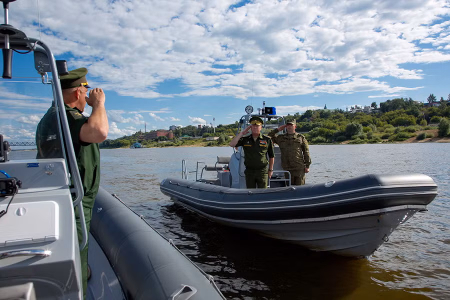 Quan chức quốc phòng Nga trên xuồng cao tốc đi thị sát cuộc thi tài dưới nước.