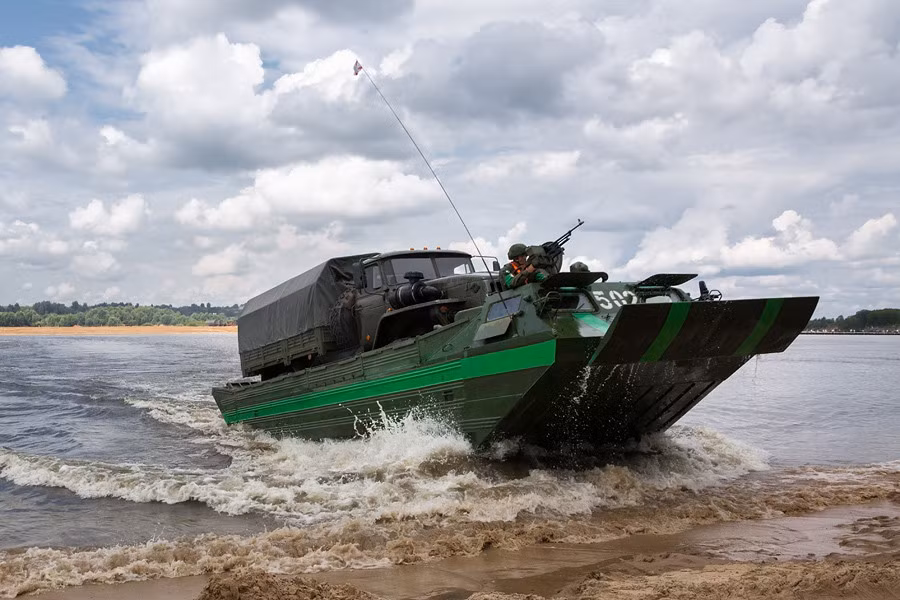 Một xe bọc thép lội nước đã tiến sát lên bờ sông.