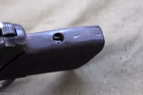 Lỗ lắp chốt vít gắn một số bộ phận của súng như tấm ốp báng súng cũng như bệ búa.