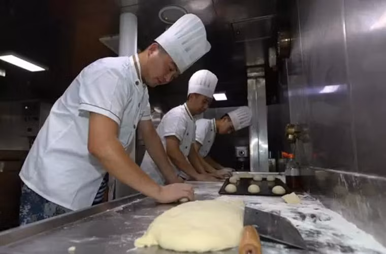 Hình ảnh các đầu bếp tàu Trường Xuân chuẩn bị đồ ăn sáng bên trong khu bếp vào lúc 5h sáng. Phục vụ gần 300 thủy thủ cùng một lúc không phải là một nhiệm vụ dễ dàng đối với các đầu bếp ở đây.