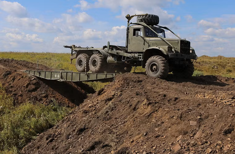 Hình ảnh Kraz-225B di chuyển chậm qua nhịp cầu của TMM-3 sau khi hoàn tất quá trình triển khai.