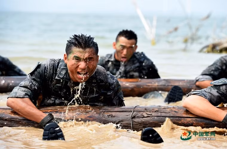 Trong ảnh là các binh sĩ Trung Quốc đang thực hiện một bài tập thể lực dưới nước với một thanh gỗ lớn.