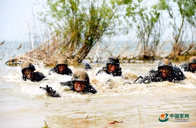 Di chuyển cơ động qua vùng đầm lầy ngập nước với vũ khí cá nhân.