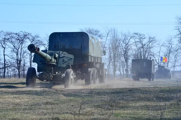 Các xe kéo pháo được hộ tống bởi các phương tiện thiết giáp hành quân ra trường bắn.