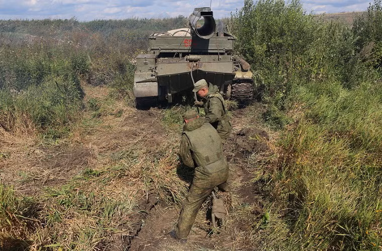 Hai binh sĩ Nga đang chuẩn bị lại hệ thống tời kéo của BTS-4 trước khi móc vào chiếc BMP-1.