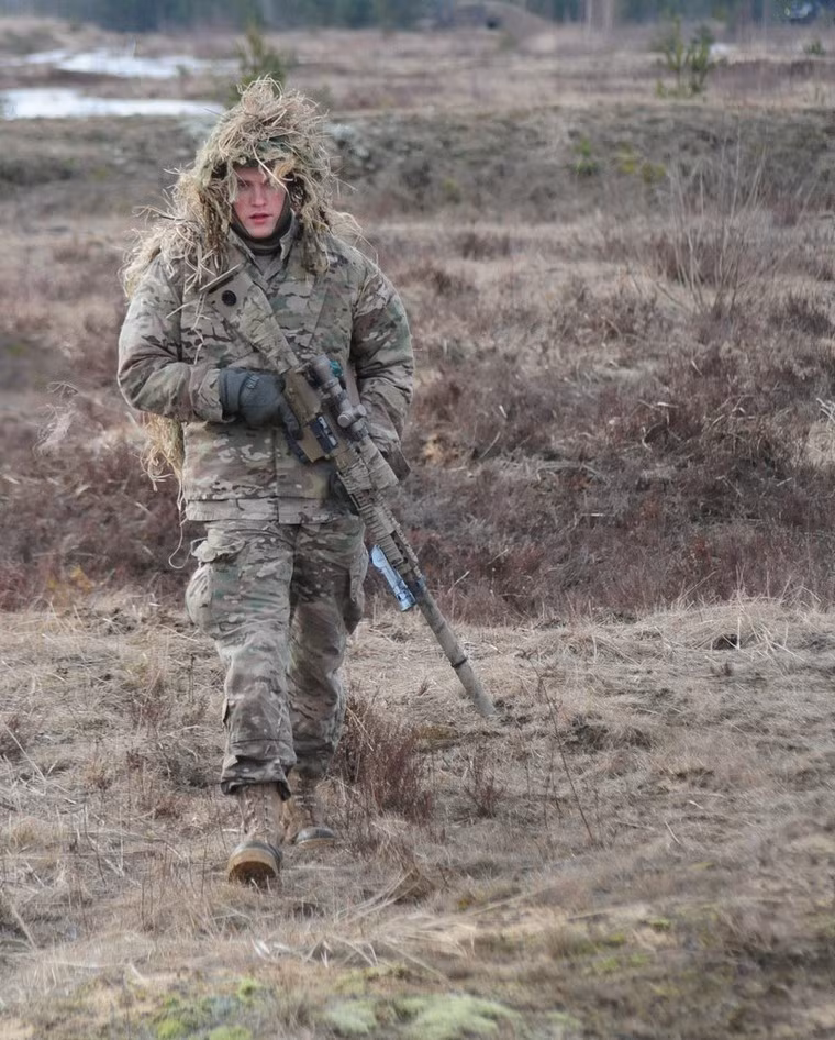 Màu áo, súng và lớp ngụy trang trùm đầu lẫn vào với màu đất và cỏ khô khiến cho đối phương khó phát hiện từ xa.